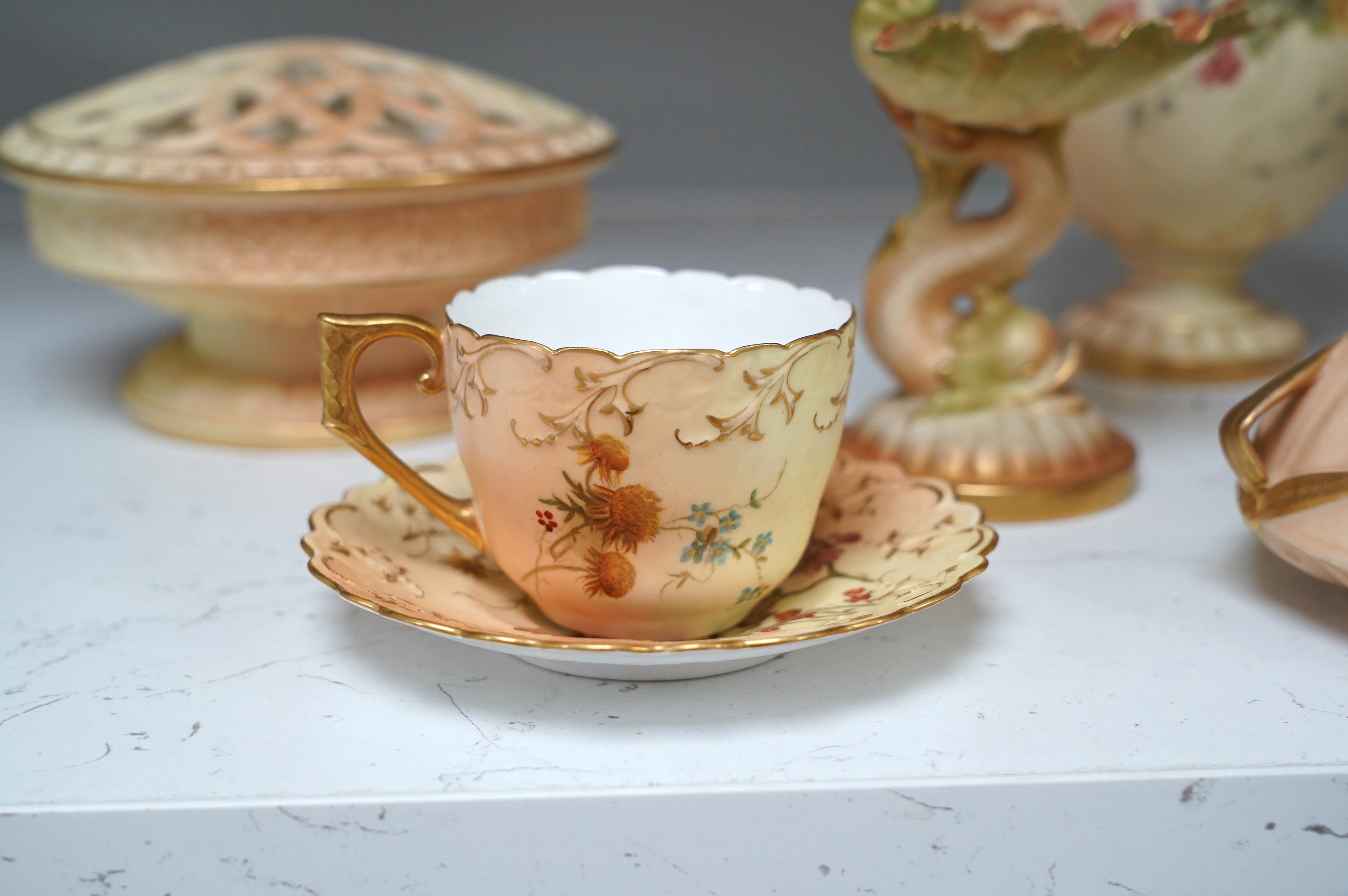 Royal Worcester blush ivory ornamental items: including a vase, two pots and covers, two dolphin stands, a cup and saucer and pierced bowl and cover (8). Condition - fair to good